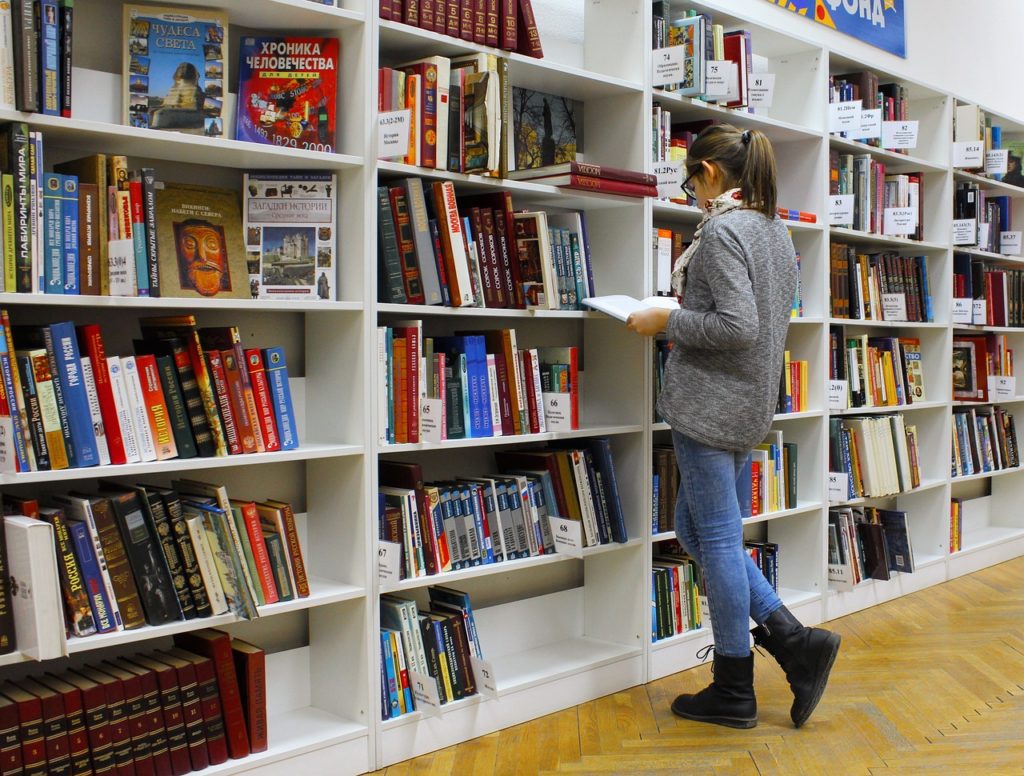 Chica leyendo un libro en una librería